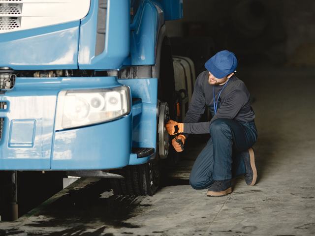 A technician working at a heavy vehicle wheel